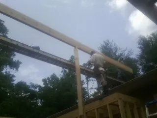 Carpenter setting a ridge beam over a new addition frame — Ice Dam Removal by Roofing Brothers in Illiopolis