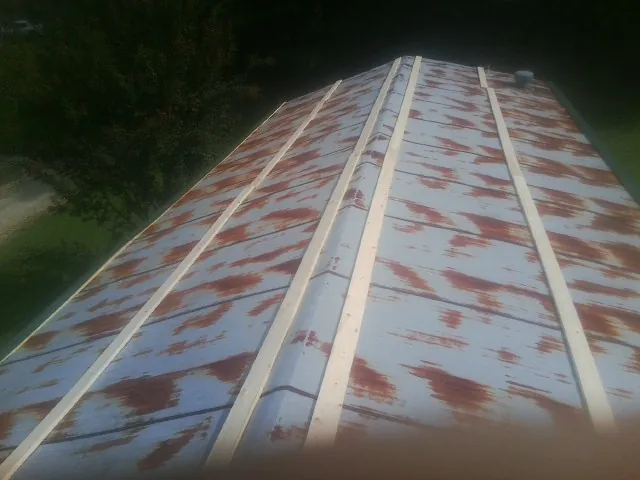 Rusted metal roof panels with new wood purlins before replacement — Storm Damage Roof Repair in Illiopolis by Roofing Brothers