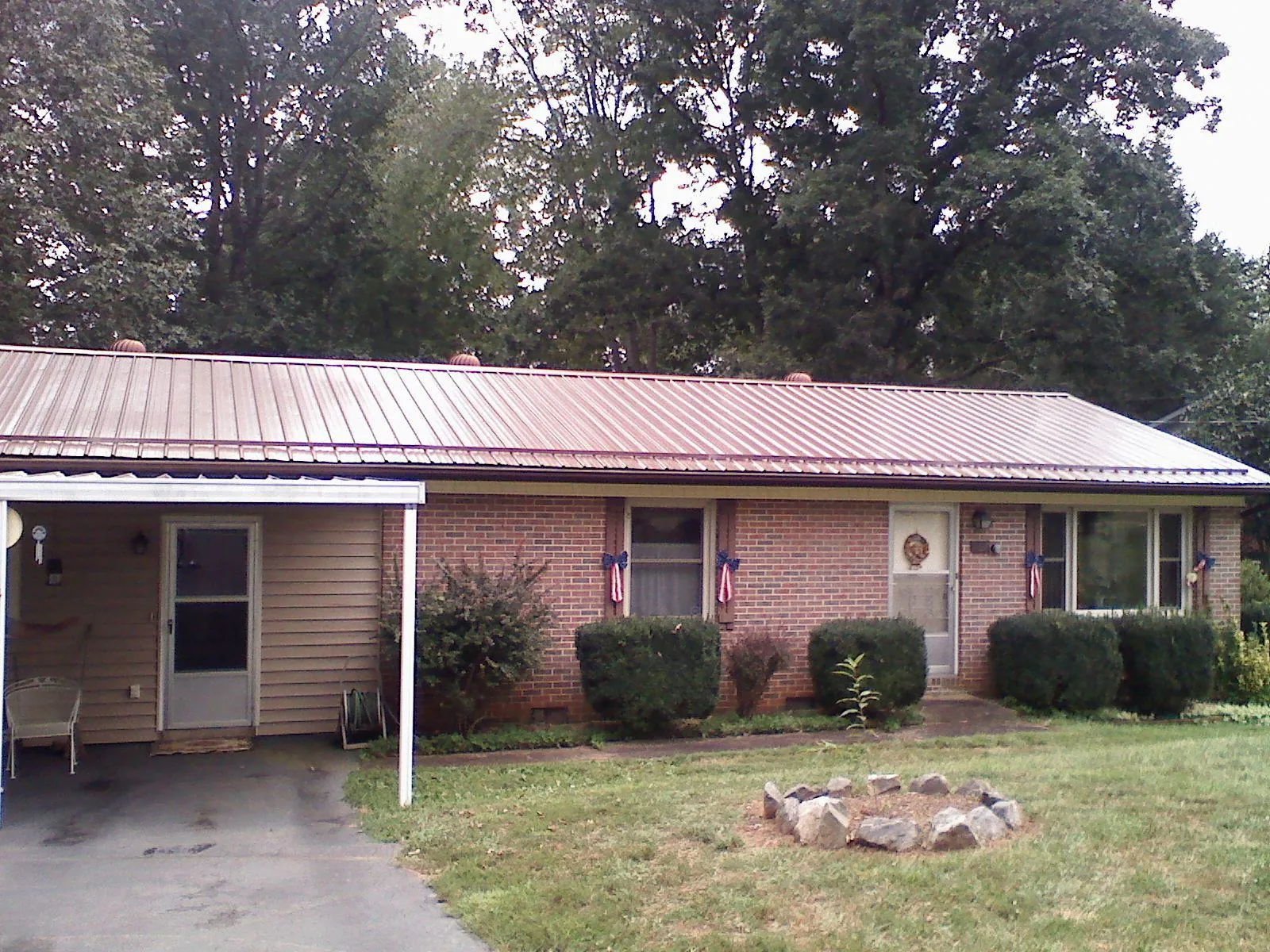 Bronze metal roof and carport on a brick ranch home — Roof Repair work by our crew in Illiopolis